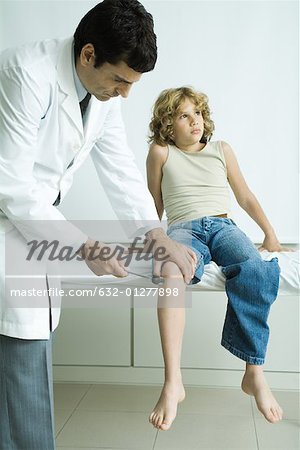 Doctor checking boy's reflexes