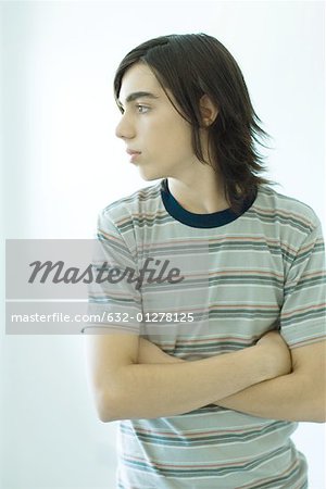 Teenage boy standing with arms crossed