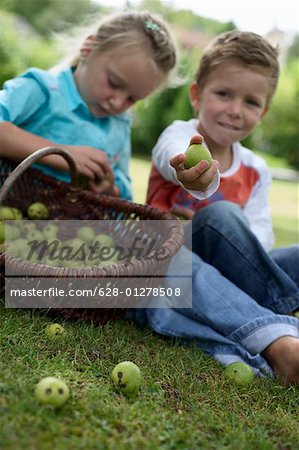 Little girl and boy with a basket of limes, selective focus