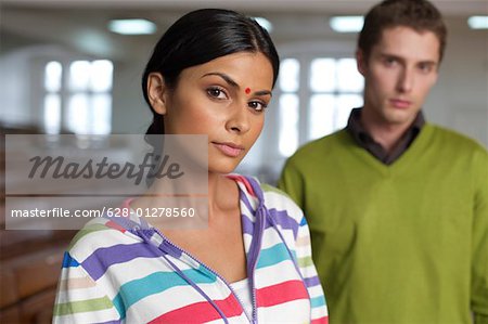 Indian woman in front of a young man, both in an auditory, selective focus