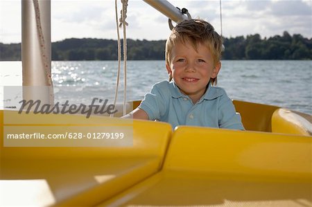 Little boy driving a plastic boat