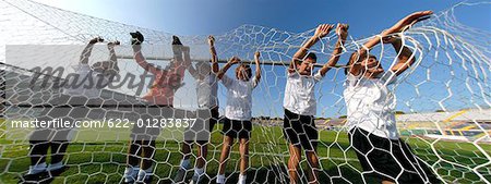 Team of boys grabbing onto the net