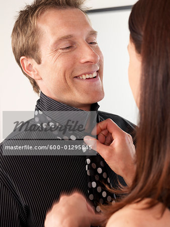 Woman Tying Man's Necktie