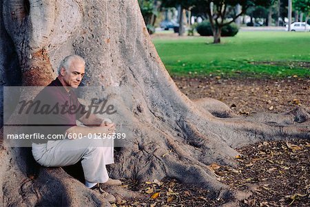 Man Sitting at Base of Tree