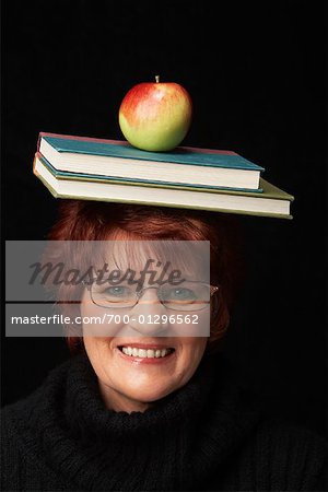 Woman Balancing Books and Apple on Her Head