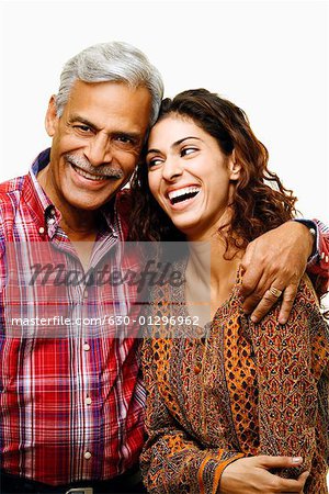 Close-up of a senior man smiling with his arm around his daughter