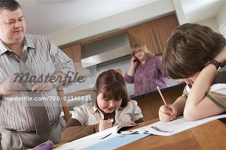 Père observer les enfants faire leurs devoirs