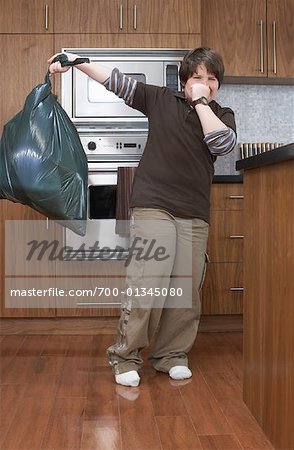 Garçon avec sac à ordures de cuisine