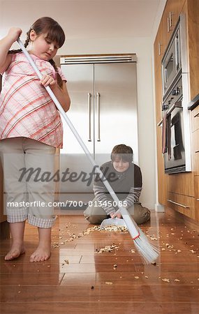 Boy and Girl Sweeping Kitchen Floor