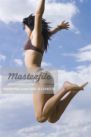Profile of a young woman jumping in air