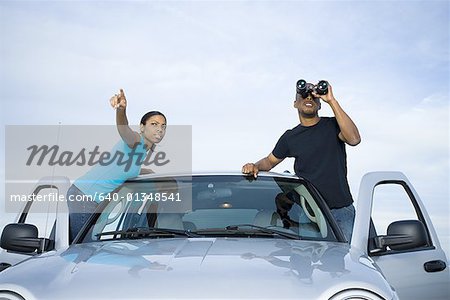 Jeune homme et une jeune femme debout près d'une voiture