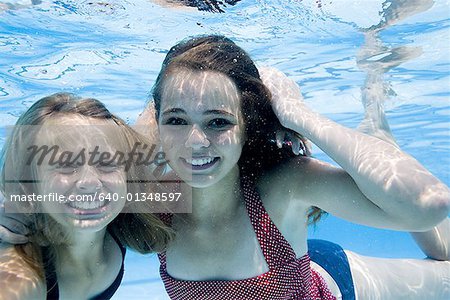 Girls swimming underwater in pool