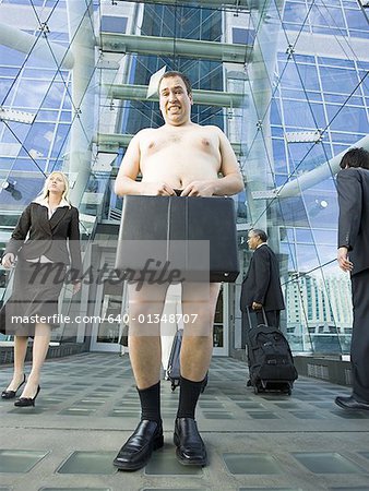 Faible angle vue d'un homme nu, tenant un porte-documents
