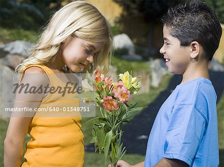 Voir le profil:: un garçon donnant des fleurs à une jeune fille