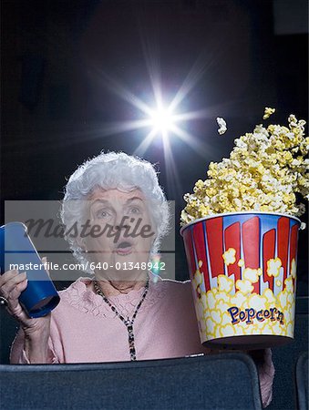 Woman watching film at movie theatre frightened