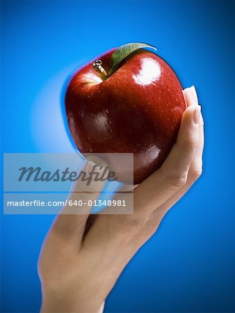 Close-up of a woman's hand holding an apple