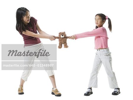 Two girls fighting over a teddy bear