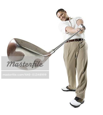 Mid adult man swinging a golf club