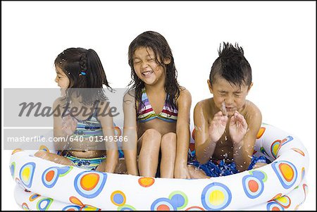 Three young girls playing in inflatable pool