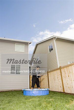 Low angle view of a businessman using a laptop while standing in a wading pool