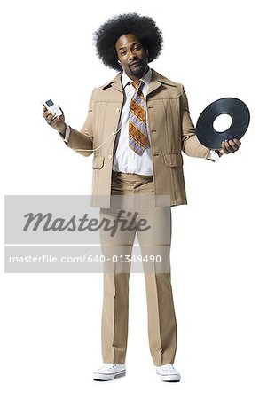 Homme avec un afro en costume beige à l'écoute de MP3 player