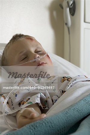 Garçon couché dans un lit d'hôpital à travers un tube de respiration