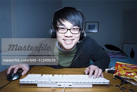 Mann am Keyboard mit Headset lächelnd