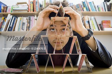 Young man building a house of cards