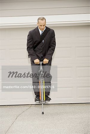 Businessman on a pogo stick
