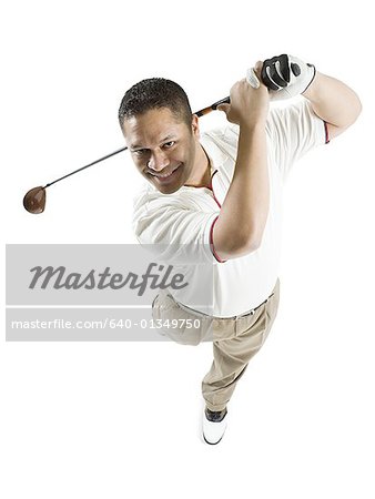 High angle view of a mid adult man swinging a golf club