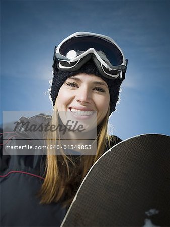 Portrait d'une jeune femme tenant une planche à neige