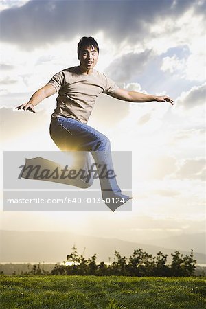 Jeune homme sautant sur l'herbe