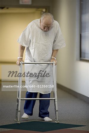 Male patient walking with a walker in a corridor
