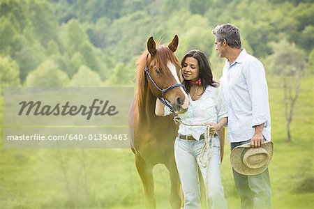 homme et une femme debout avec un cheval