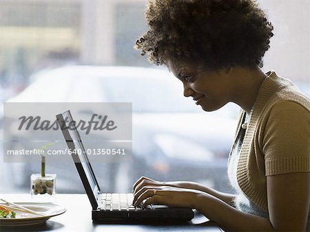 Profile of a young woman working on a laptop