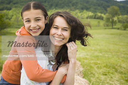 Portrait d'une jeune fille embrassant sa mère par l'arrière