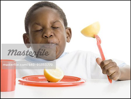 Gros plan d'un garçon manger un citron