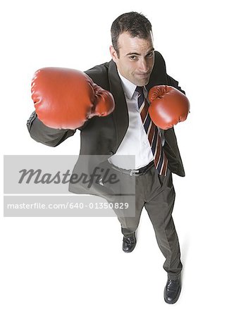 Vue grand angle sur un homme d'affaires avec des gants de boxe et de poinçonnage