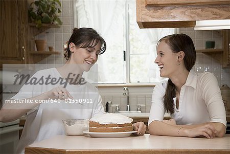 Gros plan d'une mère avec sa fille à glacer un gâteau