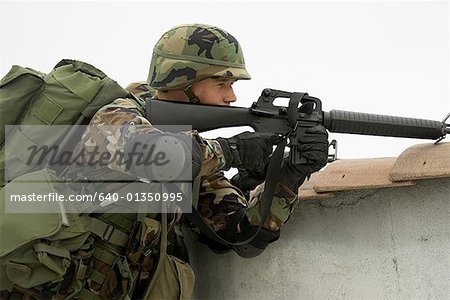 Profil de côté d'un soldat visant son fusil