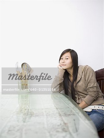 Femme assise à une table avec des ustensiles de cuisine