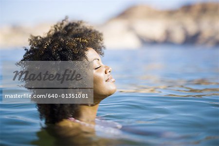 Gros plan d'une jeune femme avec les yeux fermés dans l'eau