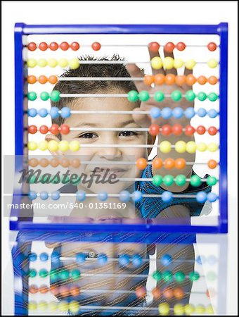 Portrait of a boy smiling behind an abacus