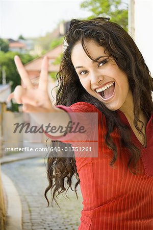 Portrait of a young woman giving a peace sign