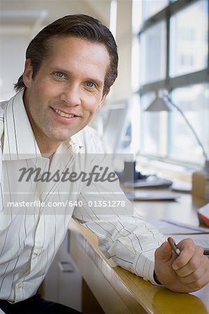 Portrait of a businessman resting his hand on the table