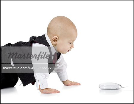 Petit garçon en costume de ramper vers la souris d'ordinateur