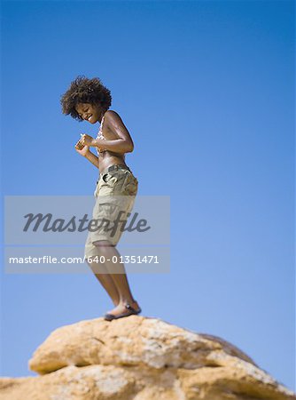 Vue d'angle faible d'une jeune femme qui danse sur un rocher