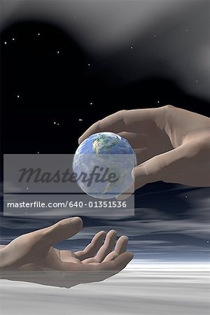 Close-up of a person's hand passing a globe to another person's hand