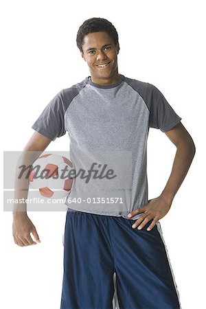 Portrait of a teenage boy with a football under his arm