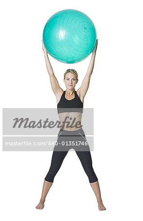 Portrait d'une jeune femme tenant un ballon de fitness